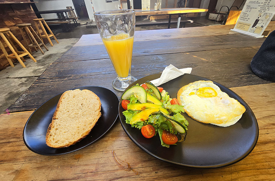 Desayuno con pan, huevo frito acompañado de ensalada y zumo de naranja en Oaxaca by Locals - Dónde comer en Oaxaca