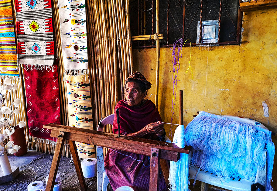 Mujer cosiendo de manera artesanal en Teotitlán del valle - las mejores excursiones de Oaxaca