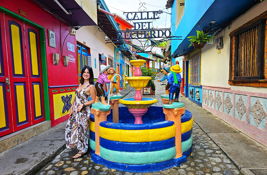 Apoyada en la Fuente de la Calle del Recuerdo, la fuente más bonita que ver en Guatapé