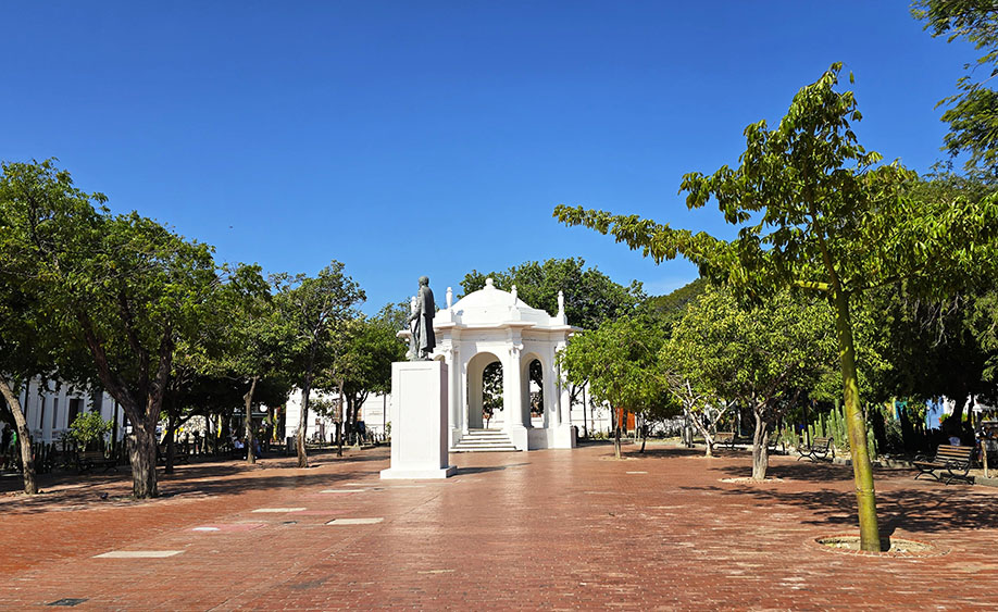 Templete de color blanco con una estatua frente a él y árboles a los lados - Parque de los novio, el mejor parque que ver en Santa Marta