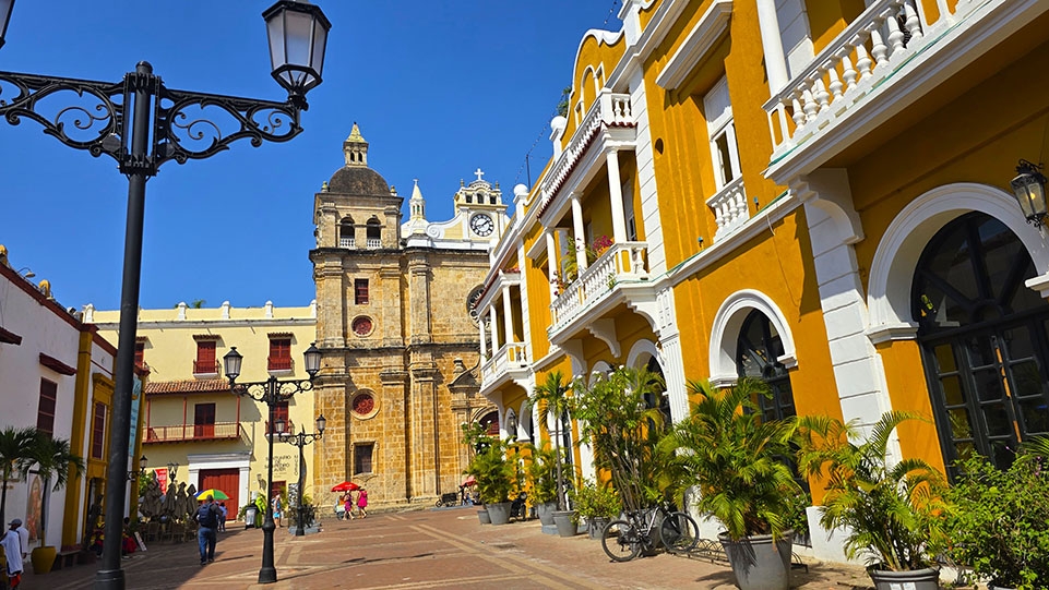 Qué ver en Cartagena de Indias: Santuario San Pedro Claver al fondo junto a un edificio colonial de color ambar