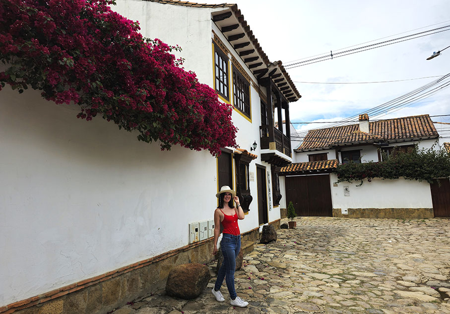 En una de las calles de Villa de Leyva con una buganvilla a la izquierda - Qué ver en Villa de Leyva
