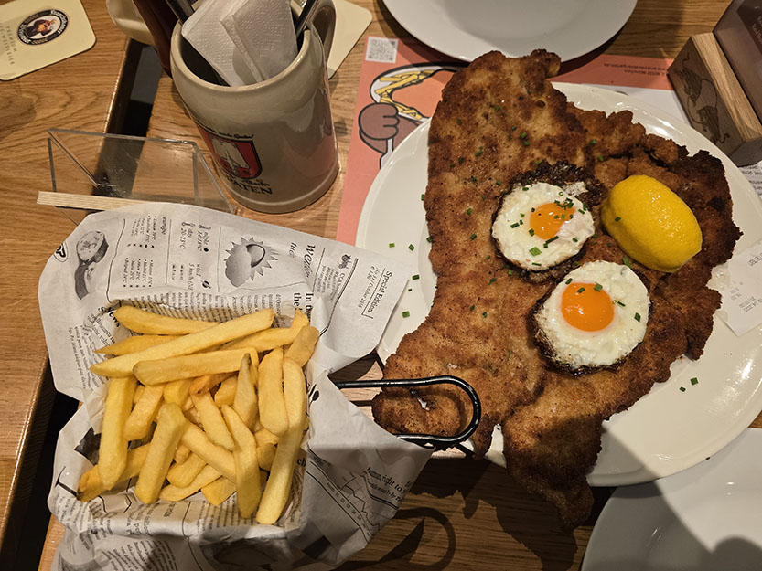 plato de schnitzel con huevos y patatas en Andy's Krabergarten, uno de los mejores restaurantes donde comer en Múnich