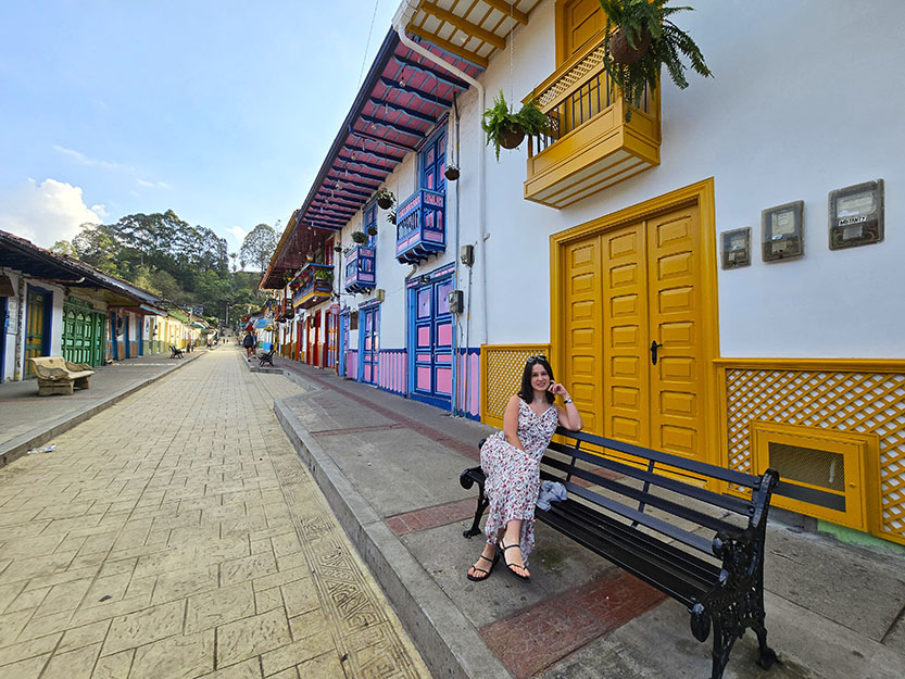 Sentada en un banco en la calle principal de Salento - qué ver en Filandia