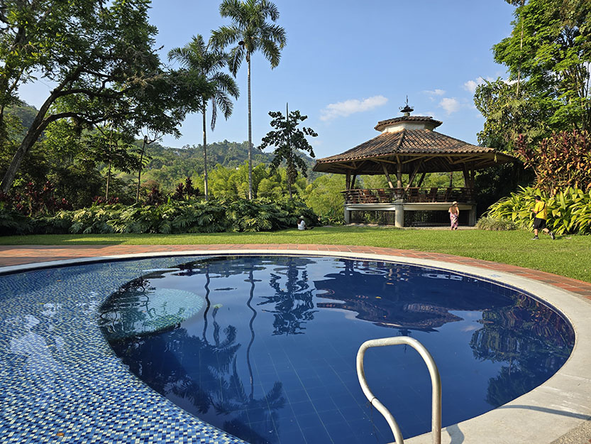 Piscina redonda con merendero al fondo en Hacienda Venecia - Visitar una hacienda cafetera en el Eje Cafetero