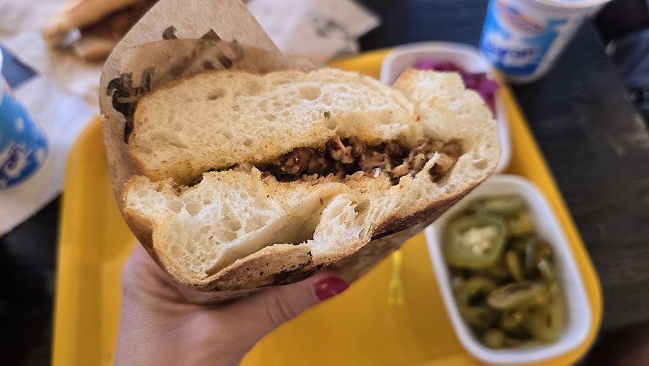 Bocadillo de Kokoreç y pepinillos al fondo - Qué comer en Turquía