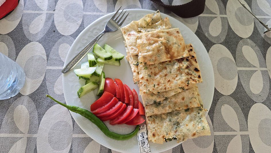 Plato de Gözleme acompañado de pepinos y tomates torceados y una guindilla - Qué comer en Turquía