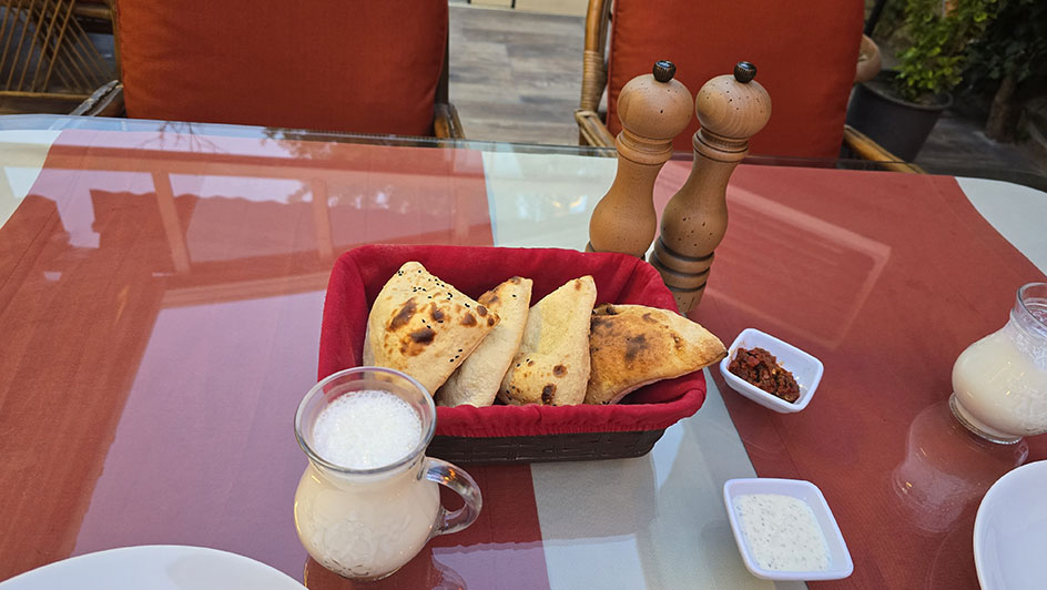 Jarra de Ayran con panecillos en una cesta y dos molinillos detrás - Qué comer en Turquía