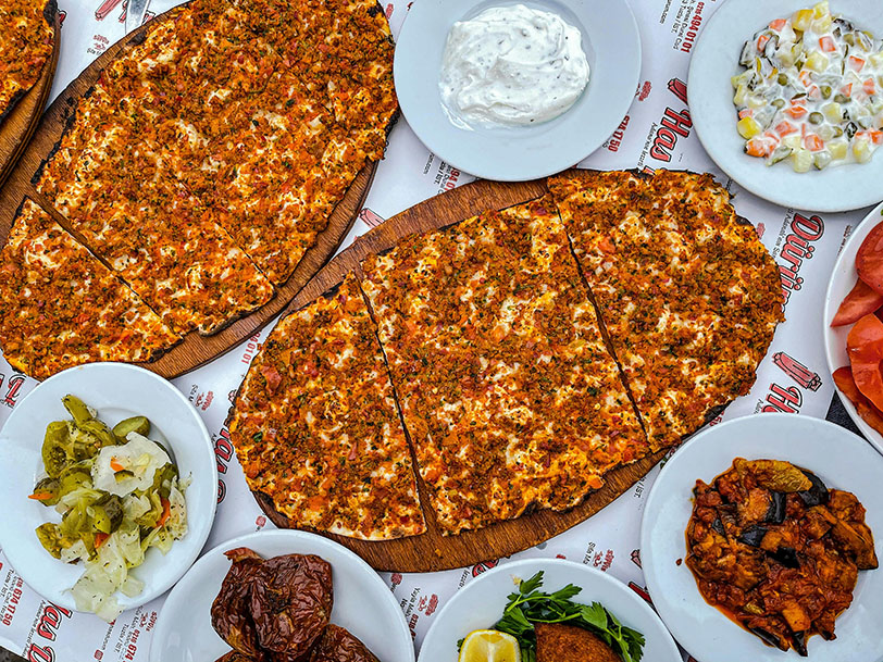 dos platos de Lahamacun rodeados de aperitivos turcos  - Qué comer en Turquía