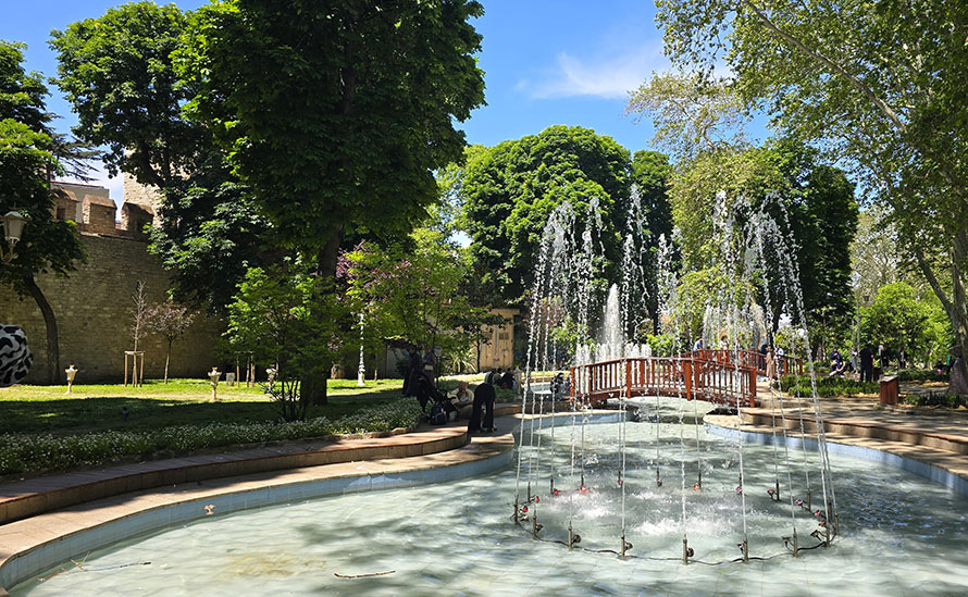 Fuente frente a un puente rojo rodeado de árboles en el Parque Gülhane - Qué ver en Estambul