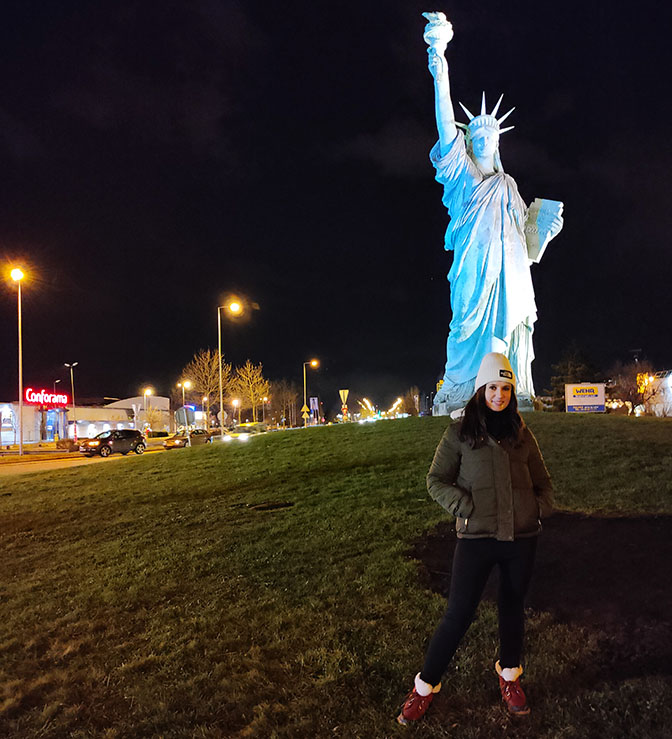 Posando frente a la Estatua de la Libertad iluminada - Qué ver en Colmar