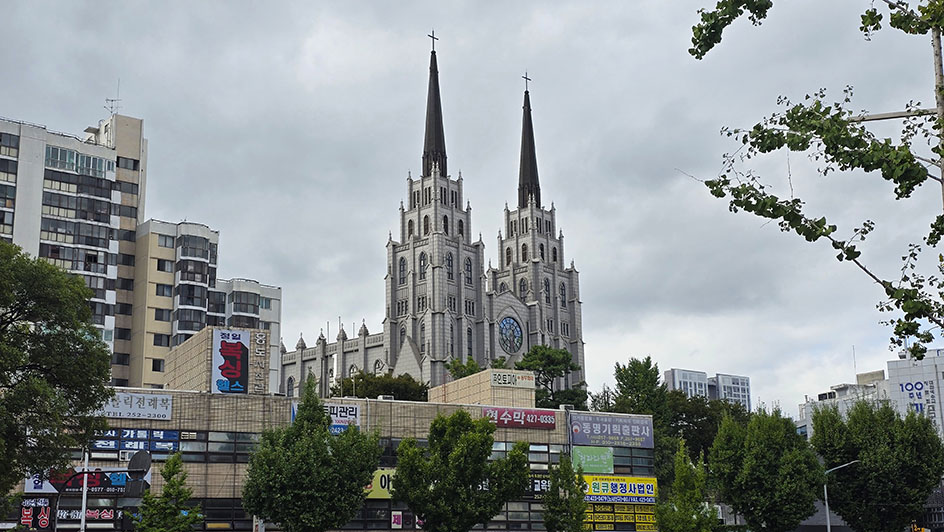 Iglesia con dos torres y de color blanca entre edificios - Qué ver en Daegu