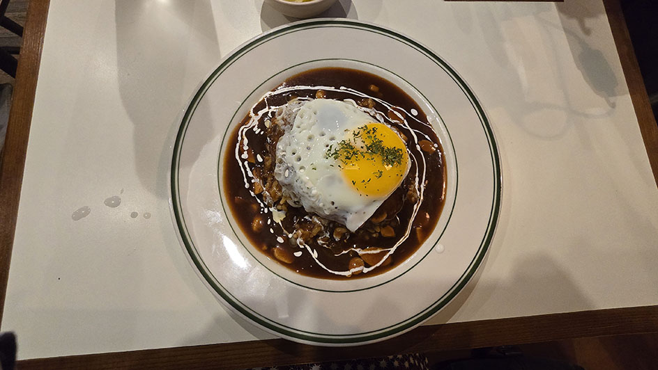 Plato con un huevo frito en lo alto y salsa marrón - Dónde comer en Seúl