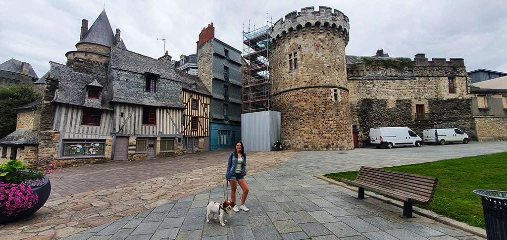 Posando con mi perro frente a una torre y casas de entramado de madera al fondo - Ruta por la Bretaña Francesa