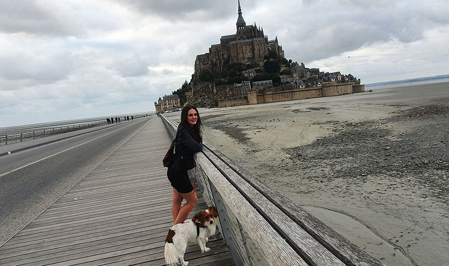 Asomada con mi perro en el camino que va hacia la abadía y con ella al fondo - Cómo visitar el Mont Saint-Michel