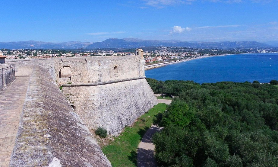 Murallas de una fortaleza con mucha vegetación a un lado y vistas a la costa - Qué ver en Antibes