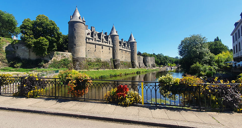 Castillo de Josselin a orillas del río visto desde el puente decorado con flores - Los pueblos más bonitos de la Bretaña Francesa