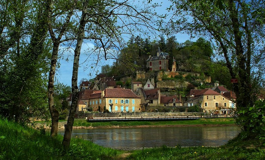Casas de piedra y castillo al fondo del río - Ruta por el Périgord Negro en 4 días