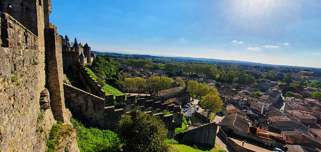 Las murallas a la izquierda con el pueblo y los árboles a la derecha - Qué ver en Carcassonne