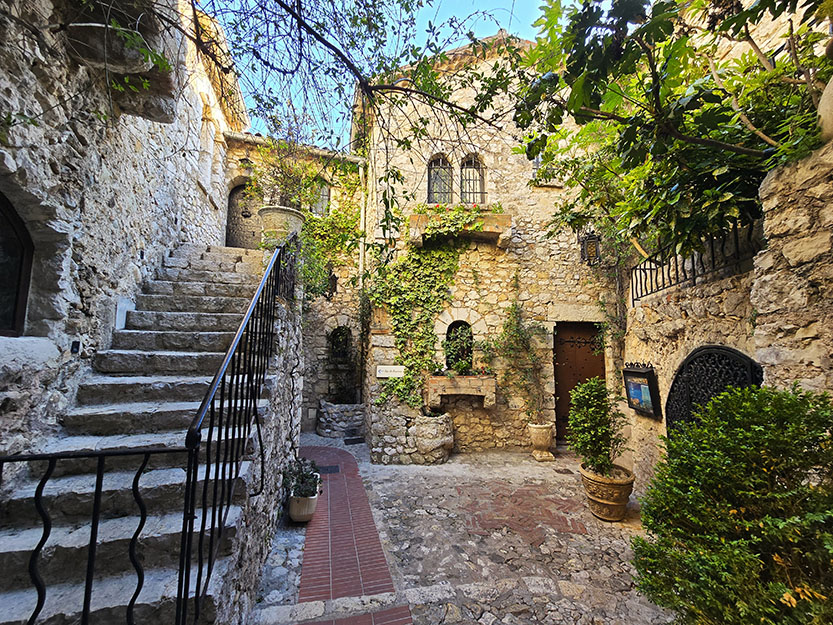 Escaleras a la izquierda, casa de piedra con plantas - Qué ver en Èze
