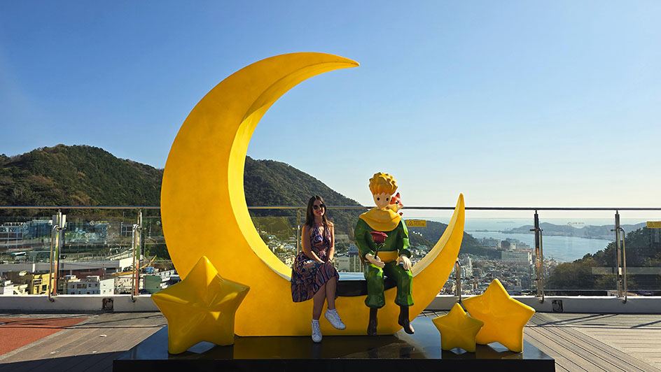 Sentada en una luna junto a la escultura del Principito y El Zorro - ruta por Corea del Sur en 15 días