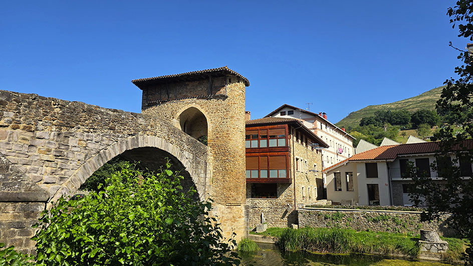 Puente de piedra sobre un río con casas al fondo - Qué ver en Balmaseda