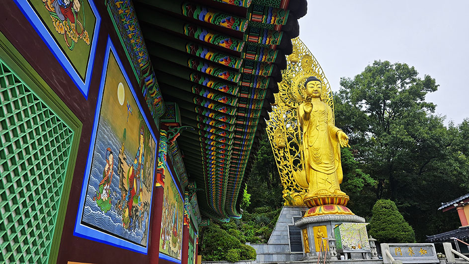 Templo de madera lleno de colores y un buda dorado a la derecha - Qué ver en Suwon