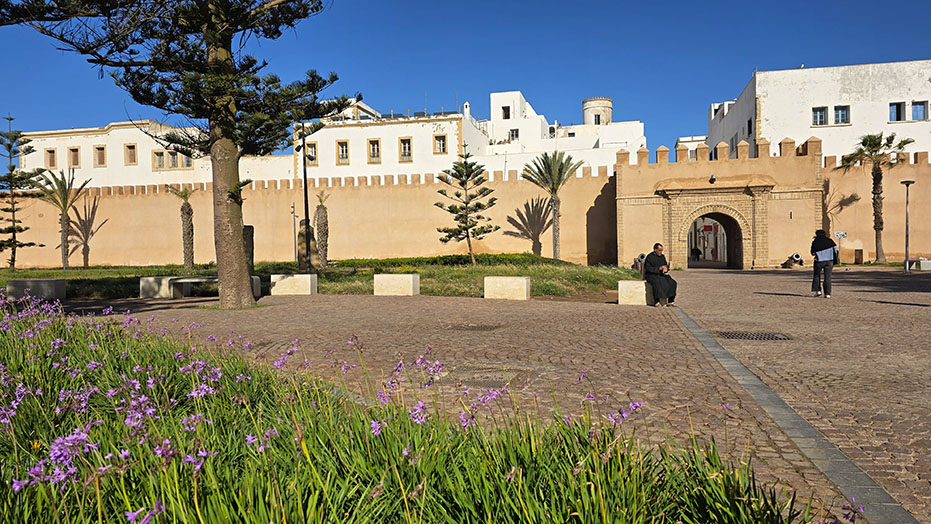 Plaza con zonas verdes y una de las puertas de entrada de las muralals 
