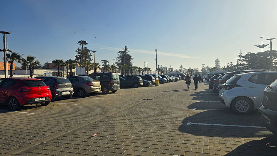 Parking Bab Marrakech al aire libre lleno de coches - Qué ver en Essaouira