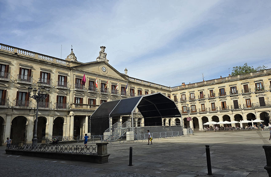 Plaza rodeada de soportales con un escenario frente al Ayuntamiento - Qué ver en Vitoria-Gasteiz