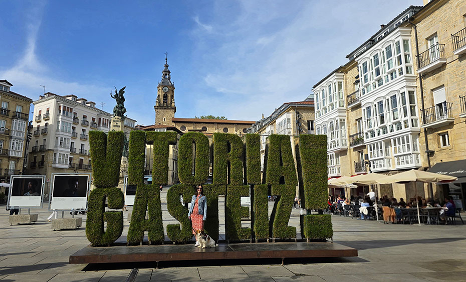 Qué ver en Vitoria-Gasteiz: Posando frente a las letras Vitoria-gasteiz en una plaza con una iglesia al fondo