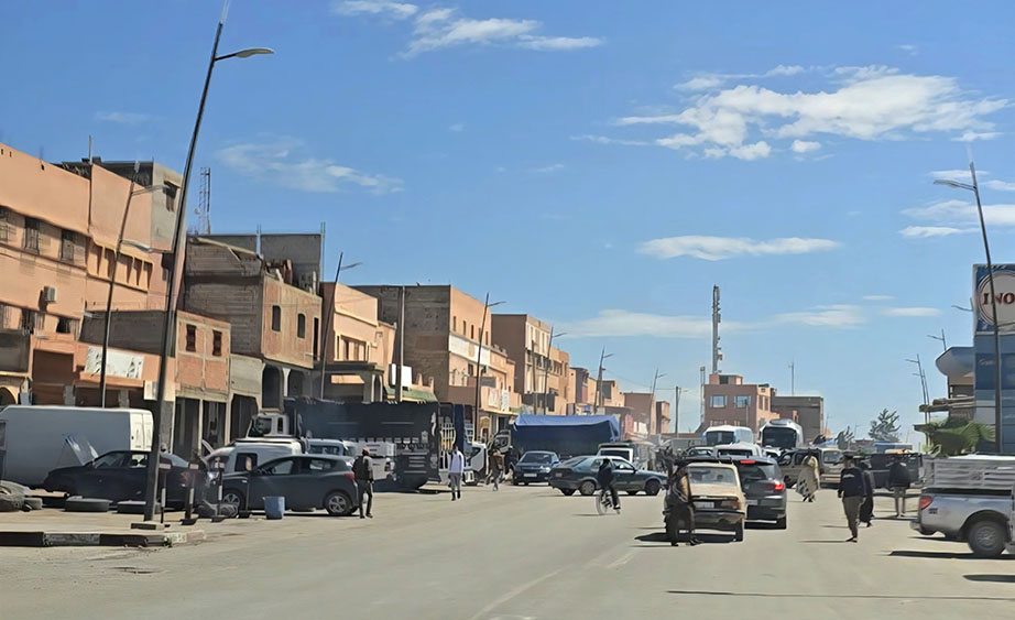 Cruzando una de las transitadas poblaciones marroquíes con coche y personas en medio de la carretera - Conducir en Marruecos