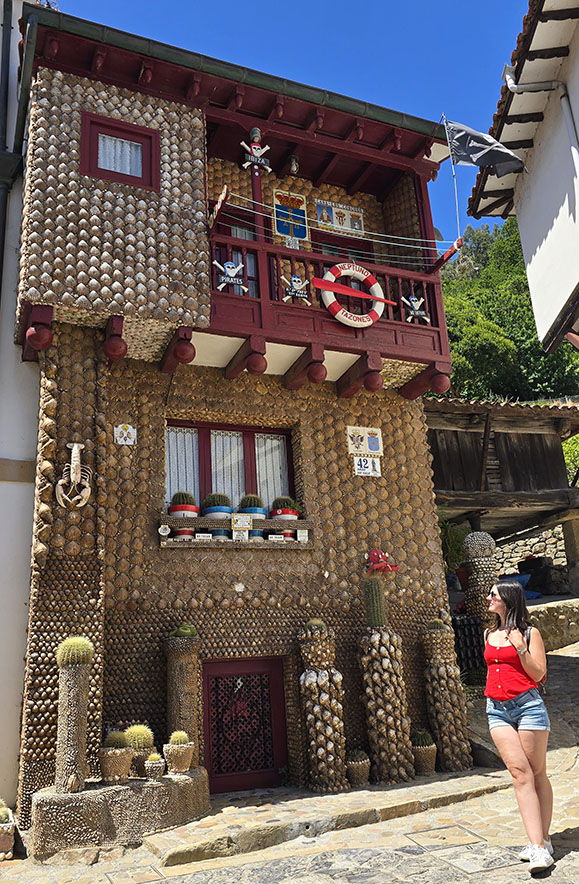 Qué ver en Tazones: posando frente a una casa de dos plantas decorada completamente con conchas