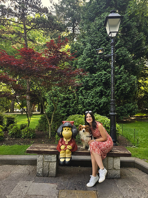 Sentada junto a mi perro en un banco con la escultura de mafalda a la izquierda - Qué ver en Oviedo