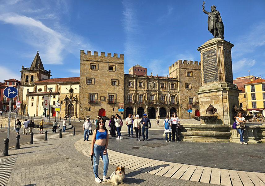 Yo con mi perro en una plaza con gente y un edificio renacentista al fondo - Qué ver en Gijón