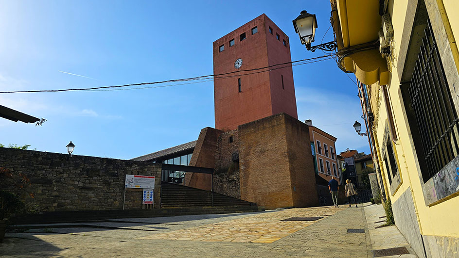 Torre de color rosado con un reloj - Qué ver en Gijón