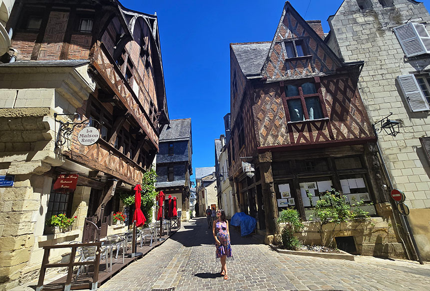 Posando en medio de una calle con casas de entramado de madera a cada lado - Qué ver en Chinon