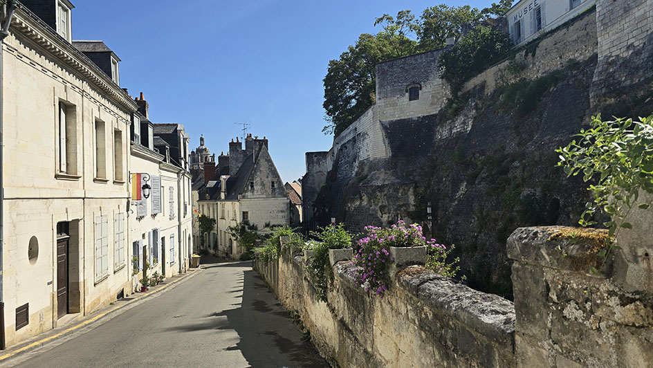 Calle de estilo medieval con una muralla a la derecha, casas a la izquierda y una bonita casa que hace esquina de frente - Qué ver en Loches