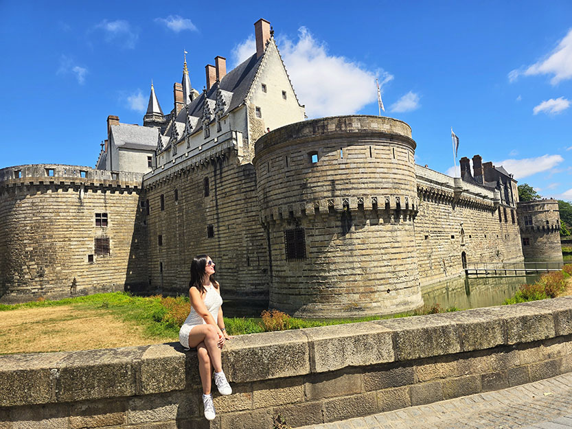 Sentada frente al Castillo de los Duques de Bretaña en Nantes, otro de los lugares que no pueden faltar durante una ruta por el Valle del Loira