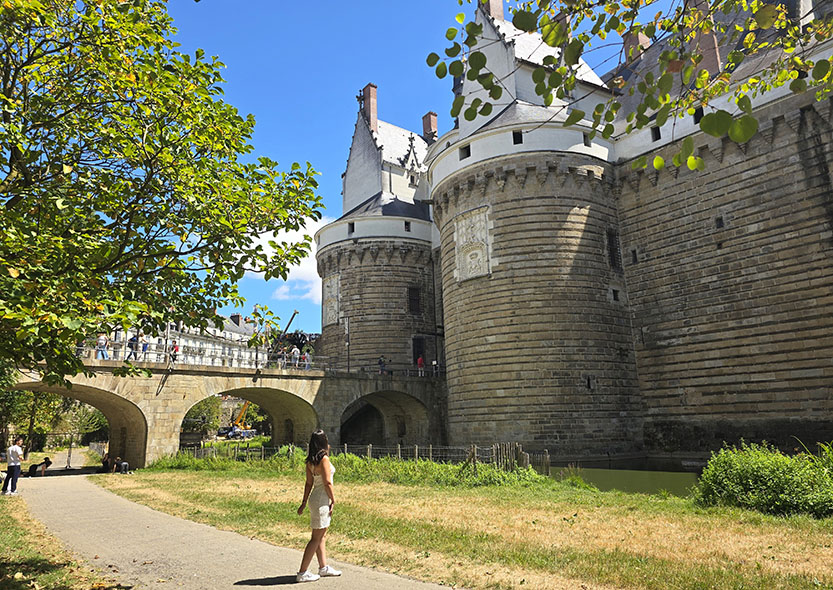 Mujer junto a la entrada principal del Castillo de los Duques de Bretaña, el monumento más importante que ver en Nantes