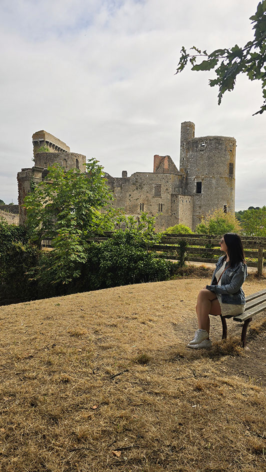 Viajera sentada contemplando el castillo de Clisson, uno de los monumentos más importantes que ver en Clisson
