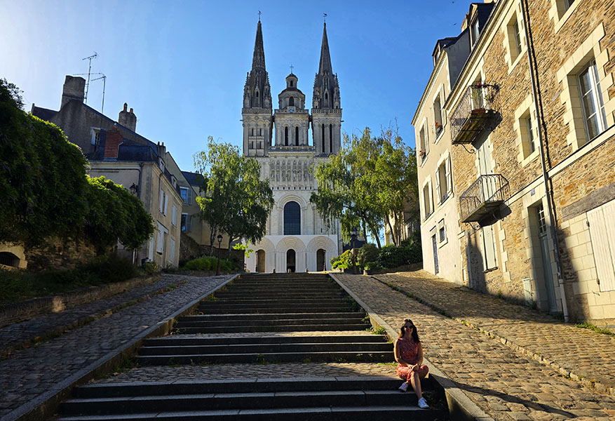 Mujer sentada en las escalinatas frente a la Catedral de Angers