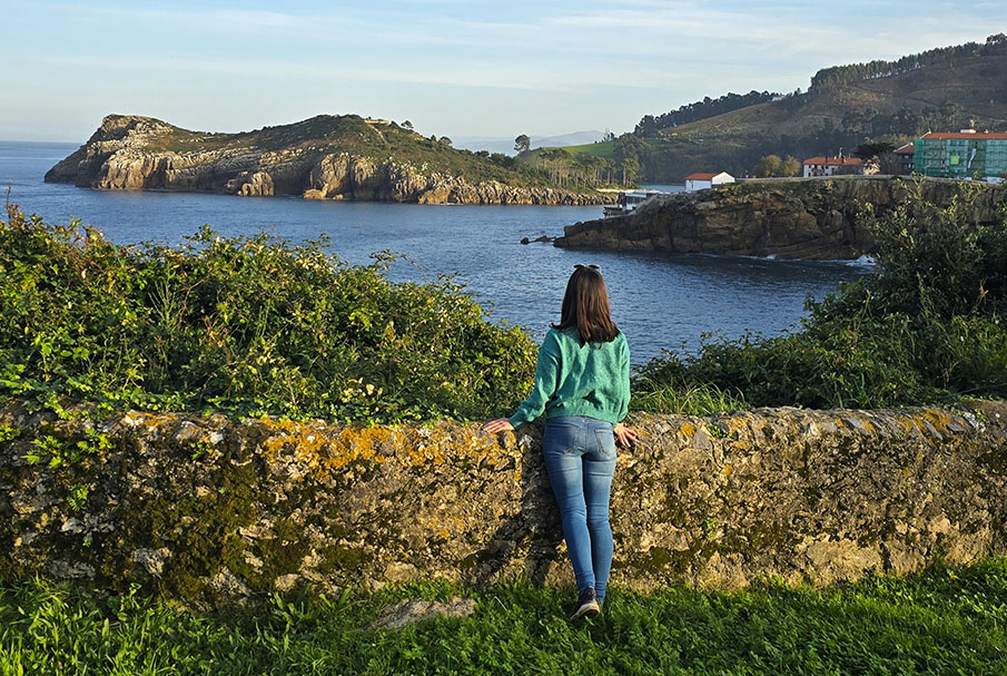 Mujer observando la Isla de Garraitz en Lekeitio, uno de los pueblos más bonitos del País Vasco