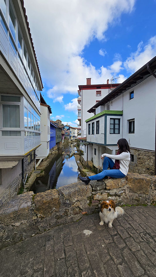 Mujer con perro observando Ea desde el puente