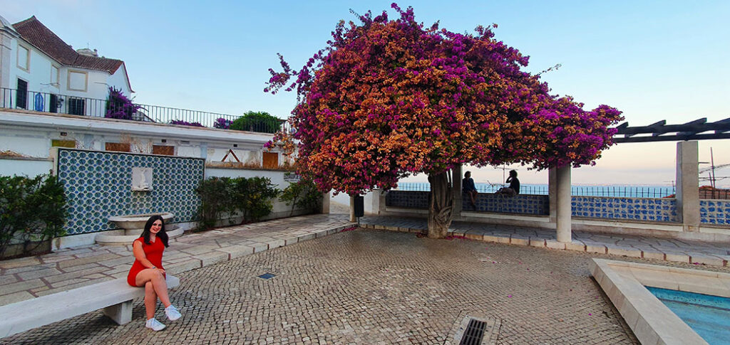 Turista sentada junto al Mirador de Santa Luzia en Lisboa - Cómo ir del aeropuerto de Lisboa al centro
