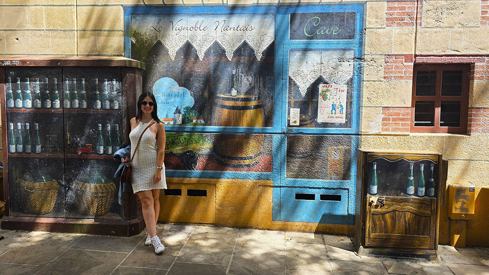 Viajera junto a un trampantojo de una bodega en la céntrica Place Ferdinand Soil, una cosa muy curiosa que ver en Nantes